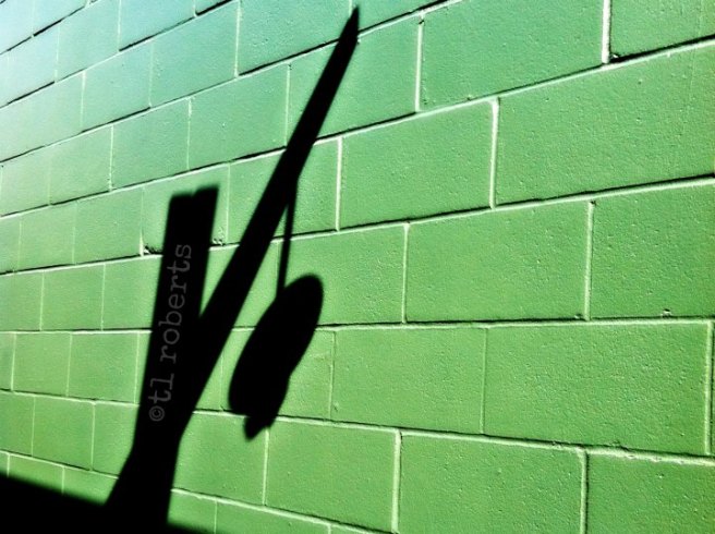 street lamp shadow on a green wall