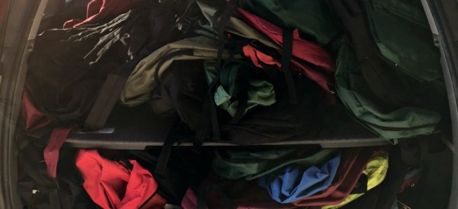 car full of empty backpacks