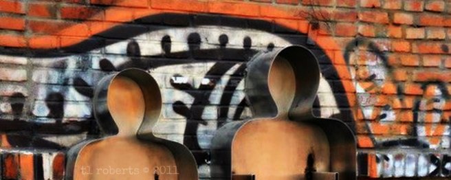 metal people sculpture with graffiti