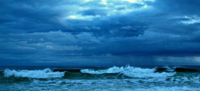 sun breaking through dark storm clouds