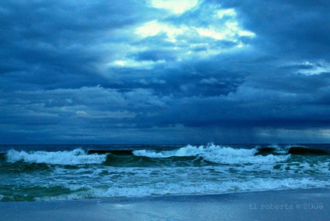 sun breaking through dark storm clouds